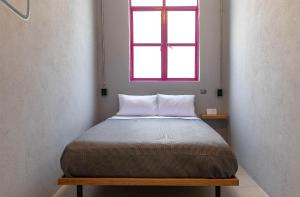 墨西哥城Hostal CASA MX bellas artes的上方窗户的房间里的一个床位