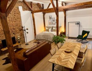 a bedroom with a bed and a couch and a table at Loft in der Innenstadt von Fulda, 60qm, privater Eingang in Fulda