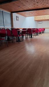 拉塞雷纳Hostal Valles del Mar的一间空房间,配有红色的椅子和桌子