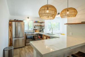 una cucina con bancone bianco e frigorifero di Casita Walk to Surf and Town a Punta Mita