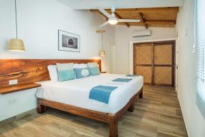 una camera da letto con un grande letto bianco con cuscini blu di Casita Walk to Surf and Town a Punta Mita