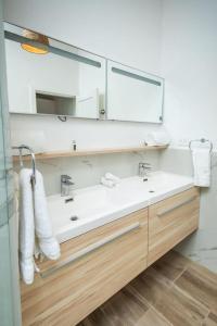 un bagno con un lavandino bianco e uno specchio di Casita Walk to Surf and Town a Punta Mita Altre 22 foto