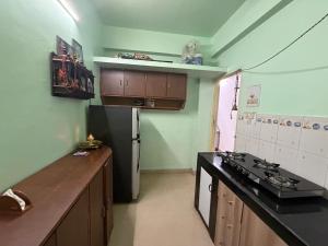 a kitchen with a stove and a refrigerator at ShivSangit 2bhk Flat Homestay in Ponda