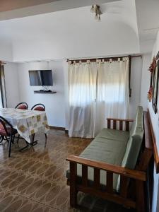 una stanza con un letto, un tavolo e una televisione di Departamento Villa Gesell 3 cuadras de la playa a Villa Gesell