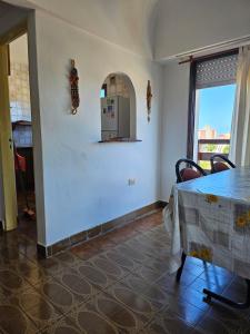 una sala da pranzo con tavolo e frigorifero di Departamento Villa Gesell 3 cuadras de la playa a Villa Gesell Altre 2 foto