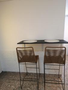un tavolo nero con due sedie accanto di La chaco a Resistencia