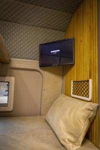 a small room with a bed and a tv on the wall at Gogo vans home on wheels in Kriva Palanka