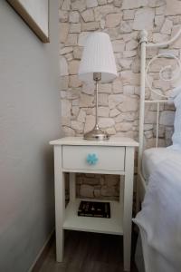 Una mesa blanca con una lámpara al lado de una cama. en Armonia Pramanta Mountain Tzoumerka, en Pramanta