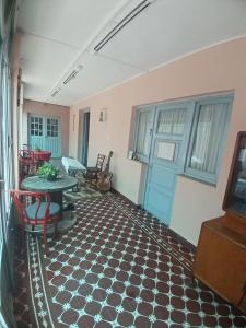 a room with a table and chairs and a blue door at La Casona Hostel in Bermejo