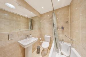 a bathroom with a toilet and a sink and a shower at Modern Hastings Home for Groups with Garden Terrace and Dedicated Workspace in Hastings