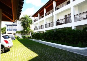 a white car parked in front of a building at Loft Moderno a Pasos de la Playa con Piscina by Caribbean Paradise Rentals in Bayahibe
