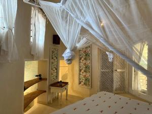 a bedroom with a bed with a white canopy at Watamu Shell House in Watamu +53 photos