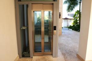an entrance to a building with glass doors at Loft Moderno a Pasos de la Playa con Piscina by Caribbean Paradise Rentals in Bayahibe +6 photos