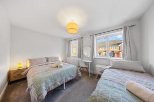 een slaapkamer met twee bedden en een raam bij Modern House - 4 bed, sleeps 8 in Hastings