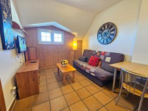 een woonkamer met een bank en een klok aan de muur bij Maribel Arttyco ERB alojamientos in Sierra Nevada