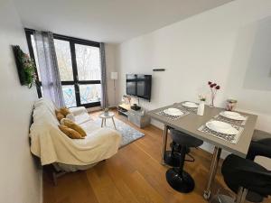 a living room with a couch and a table with a desk at Chambre City - Colocation - Métro 8 - RER 5 min in Créteil