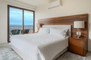 Ένα ή περισσότερα κρεβάτια σε δωμάτιο στο Luxury Canuva Beachfront Condo Pool Concierge