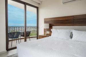 Ένα ή περισσότερα κρεβάτια σε δωμάτιο στο Luxury Canuva Beachfront Condo Pool Concierge