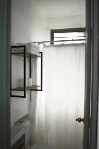 a bathroom with a white shower curtain and a toilet at Casita en el centro de Oaxaca cerca de Santo Domingo in Oaxaca City +1 photo