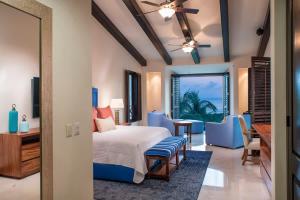 ein Schlafzimmer mit einem Bett und einem Tisch und Stühlen in der Unterkunft Luxury Oceanview Penthouse in HDM in Punta Mita