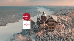 韦巴Zamek Łeba Resort & Spa的雪山上一座城堡，旁边立着一块牌子