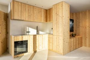 cocina con armarios de madera y fogones en Vronis Lodge, en Hart im Zillertal