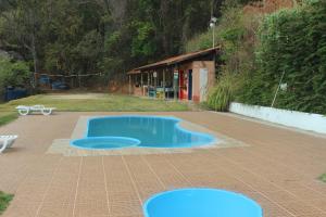 a small blue swimming pool in a parking lot at Pousada Spa Saúde Melhor in Extrema