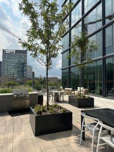 un patio con tavoli e alberi su un edificio di Bright, Modern Studio in White Plans a White Plains