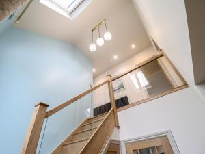 a staircase in a house with a skylight at Pistyll Ddu in Llanfairpwllgwyngyll