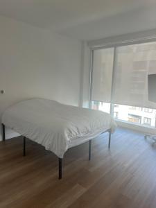 un letto in una stanza bianca con una finestra di Bright, Modern Studio in White Plans a White Plains Altre 36 foto