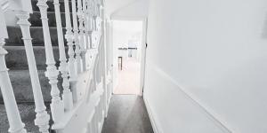 a hallway with white walls and a stair case at The Burford Hideaway in Nottingham