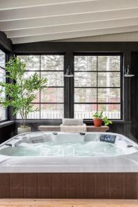 eine große Badewanne in einem Raum mit Fenstern in der Unterkunft Atlantic Pearl - Luxurious Ocean Front Experience 