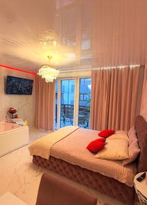 格但斯克Jacuzzi Bliss by the Motława的卧室里有一张大床，配有红色枕头