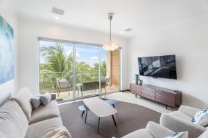 棕榈滩Eagle Beach - Luxury Beachscape 2BR condo - LV302的客厅里有一张沙发和一台电视
