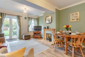 un soggiorno con tavolo e camino di 1 Pump Cottages a Theberton