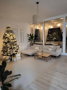 a living room with a christmas tree and a couch at Oáza Apartmán in Poprad