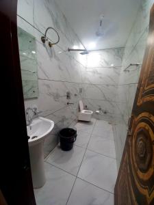 ein weißes Badezimmer mit Waschbecken und Toilette in der Unterkunft Hotel A regency in Ludhiana
