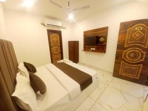 ein Schlafzimmer mit einem Bett und einem Fernseher darin in der Unterkunft Hotel A regency in Ludhiana