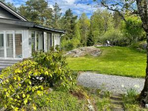 a house with a gravel path next to a yard at Family Cabin With Fjord Views In Drøbak Heights in Drøbak