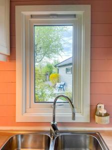 a kitchen sink with a window above a kitchen counter at Family Cabin With Fjord Views In Drøbak Heights in Drøbak