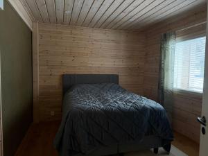 una camera da letto con un letto in una parete di legno di Villa Siltasaari a Sotkamo
