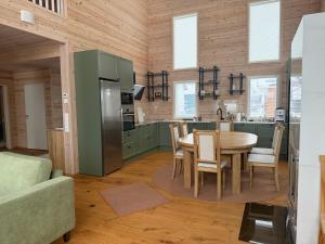 una cucina con mobili verdi, tavolo e sedie di Villa Siltasaari a Sotkamo