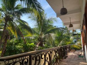 a balcony of a house with palm trees at Hostal Axlan in Puerto Escondido