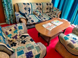 a living room with couches and a table and chairs at Kumbh Mela Vikas home stay in Prayagraj +1 photo
