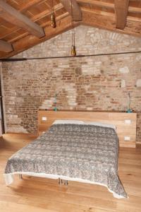 a bed in a room with a brick wall at Villa Cortellini in San Clemente