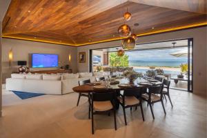 a dining room with a table and a couch at Beachfront Villa with Butler and Private Pool in Punta Mita