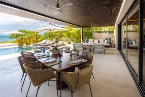 a dining room with a table and chairs and the ocean at Beachfront Villa with Butler and Private Pool in Punta Mita