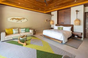 a bedroom with a bed and a couch at Beachfront Villa with Butler and Private Pool in Punta Mita +36 photos