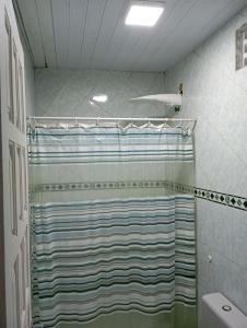 ein Badezimmer mit Dusche mit gestreiftem Duschvorhang in der Unterkunft Hospedagem próxima ao centro apto simples in Feira de Santana