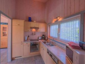 een keuken met witte kasten en een groot raam bij Ferienhaus im skandinavischen Stil in Rechlin